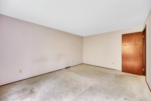 empty room with visible vents, baseboards, and carpet floors