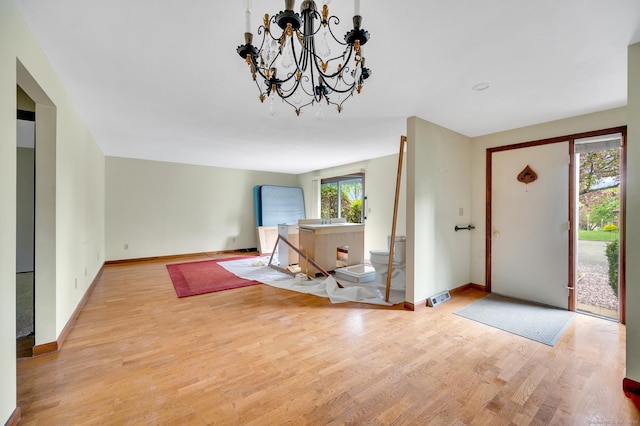 foyer featuring a chandelier, wood finished floors, and baseboards