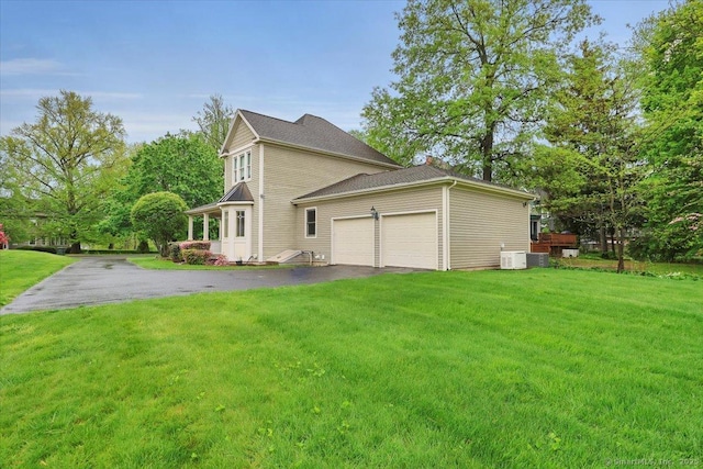 view of property exterior with a yard, driveway, central AC unit, and an attached garage
