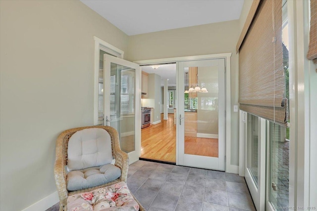 doorway to outside with baseboards, french doors, and a notable chandelier