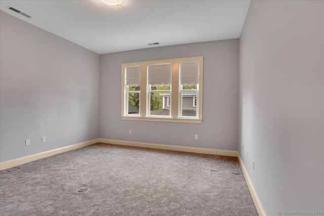 unfurnished room featuring light colored carpet, baseboards, and visible vents