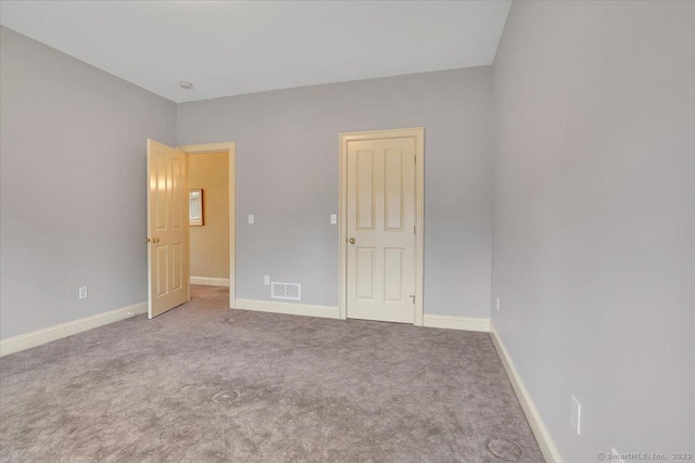 unfurnished bedroom featuring carpet flooring, visible vents, and baseboards