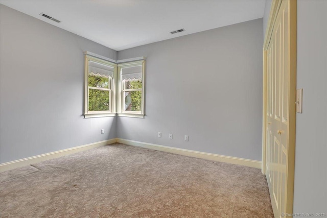 unfurnished room featuring carpet flooring, baseboards, and visible vents