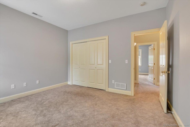 unfurnished bedroom with baseboards, a closet, visible vents, and carpet floors