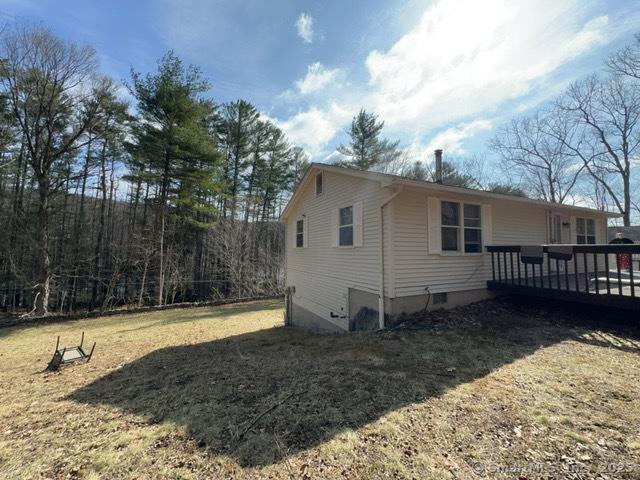 view of side of home featuring a yard and a deck