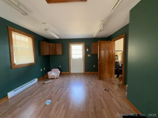 interior space featuring light wood-style floors, baseboards, and a baseboard heating unit