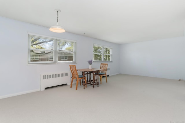 dining area featuring light colored carpet and radiator heating unit