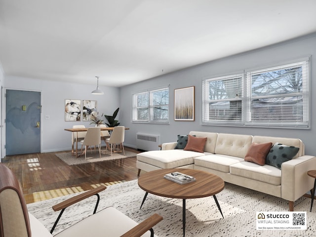 living room featuring wood finished floors, baseboards, and radiator heating unit