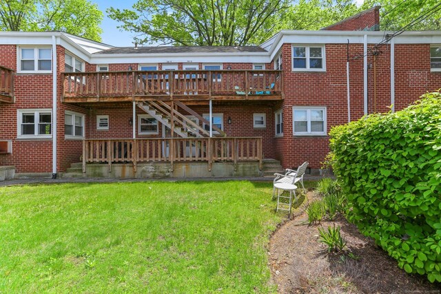 36 Courtland Ave Unit 3, Stamford, CT 06902 - back of property featuring brick siding, a wooden deck, and a lawn