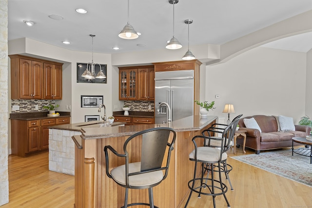 15 Hickory Hill Rd, Avon, CT 06001 - kitchen featuring built in appliances, backsplash, an island with sink, and a breakfast bar