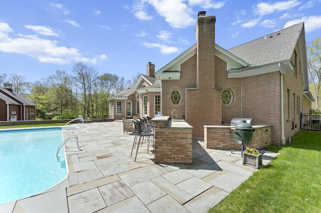 15 Hickory Hill Rd, Avon, CT 06001 - back of property featuring outdoor dry bar, brick siding, a chimney, and an outdoor kitchen