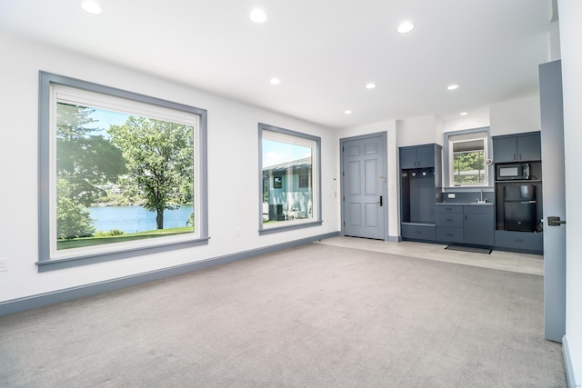 13 Kellogg St, Brookfield, CT 06804 - unfurnished living room with light colored carpet, recessed lighting, plenty of natural light, a sink, and a water view