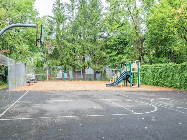 view of basketball court with community basketball court, playground community, and fence