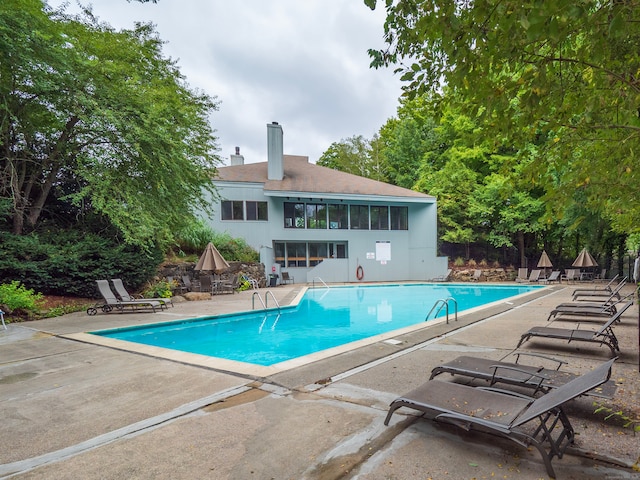 pool with a patio area and fence