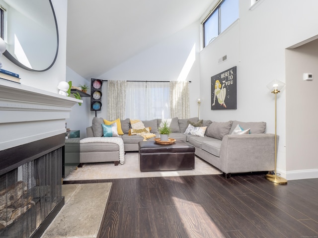 living area with wood finished floors, high vaulted ceiling, a fireplace, visible vents, and baseboards