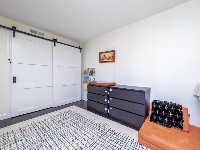 bedroom with visible vents and a barn door