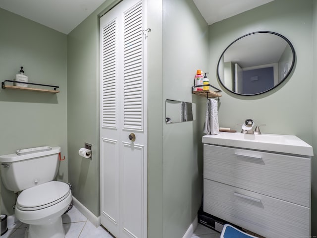 half bathroom with vanity, toilet, baseboards, and tile patterned floors