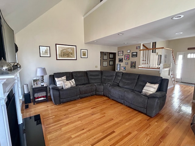 92 Sherwood Ln, Norwich, CT 06360 - living room featuring light wood-style floors, stairway, and a fireplace with flush hearth