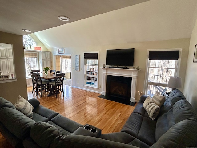 92 Sherwood Ln, Norwich, CT 06360 - living area featuring lofted ceiling, healthy amount of natural light, light wood-style floors, a fireplace with flush hearth, and baseboards