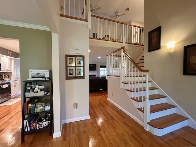 92 Sherwood Ln, Norwich, CT 06360 - stairs with ornamental molding, wood finished floors, a ceiling fan, and baseboards