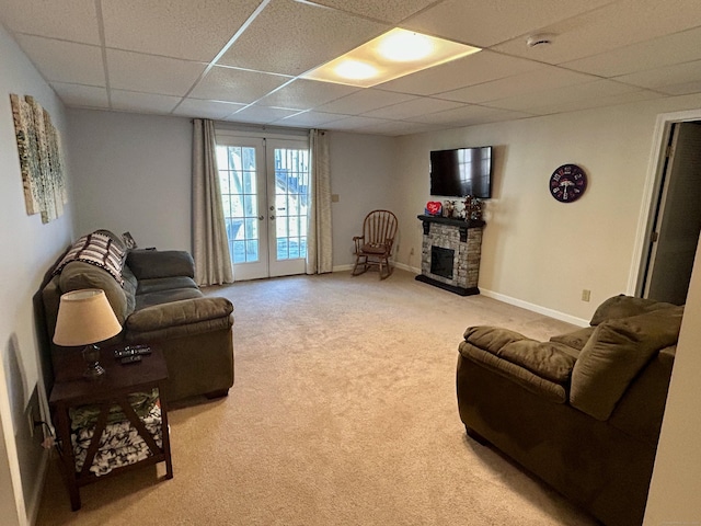 92 Sherwood Ln, Norwich, CT 06360 - living area with a drop ceiling, french doors, light carpet, baseboards, and a stone fireplace