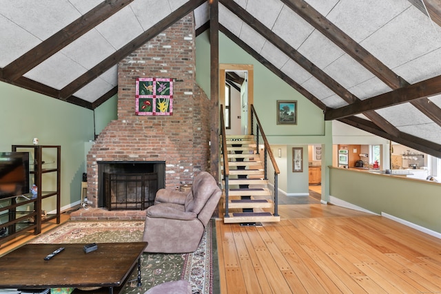 27 Whippoorwill Ln, Bethany, CT 06524 - living room featuring beam ceiling, baseboards, a brick fireplace, hardwood / wood-style flooring, and stairway