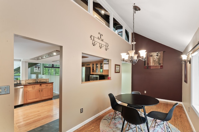 27 Whippoorwill Ln, Bethany, CT 06524 - dining space featuring light wood finished floors, a chandelier, vaulted ceiling, and baseboards