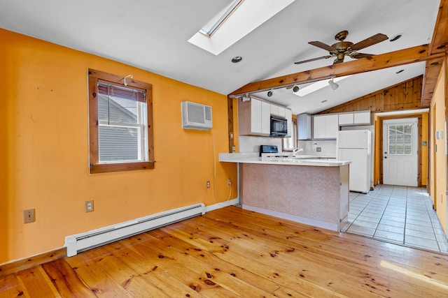 49 Hartford Ave, Old Saybrook, CT 06475 - kitchen with a baseboard heating unit, freestanding refrigerator, black microwave, a peninsula, and a skylight