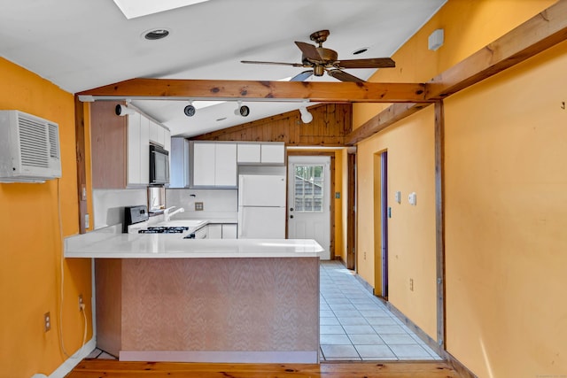 49 Hartford Ave, Old Saybrook, CT 06475 - kitchen featuring freestanding refrigerator, range, a peninsula, a wall mounted air conditioner, and white cabinetry