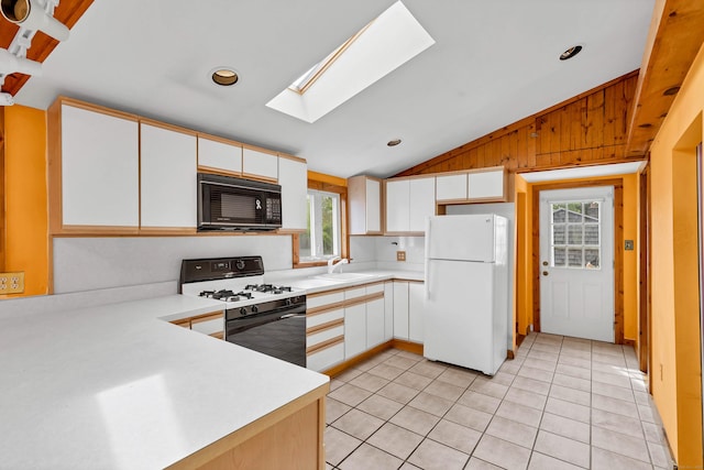 49 Hartford Ave, Old Saybrook, CT 06475 - kitchen with freestanding refrigerator, black microwave, gas range, lofted ceiling, and a sink