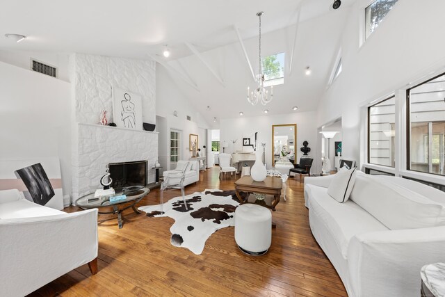10 Twin Falls Ln, Westport, CT 06880 - living room featuring high vaulted ceiling, a chandelier, a fireplace, wood-type flooring, and plenty of natural light