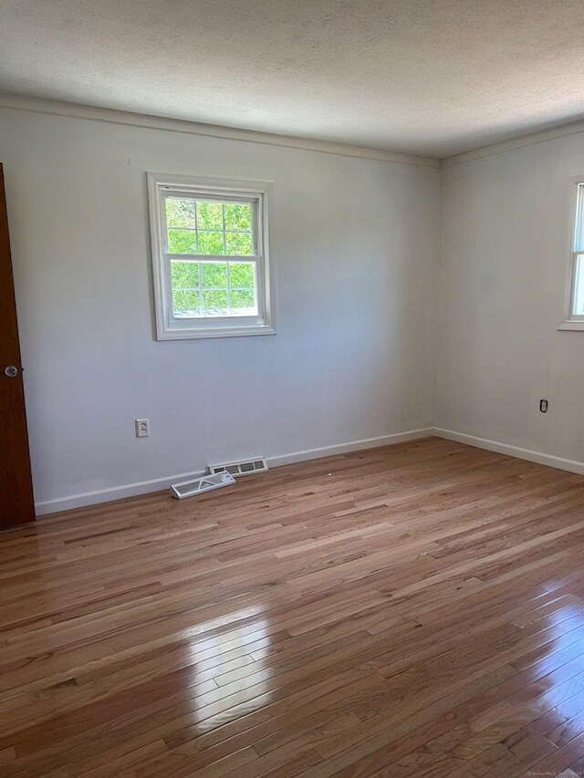 132 Walkley Dr, Southington, CT 06489 - empty room with healthy amount of natural light, wood-type flooring, a textured ceiling, baseboards, and ornamental molding