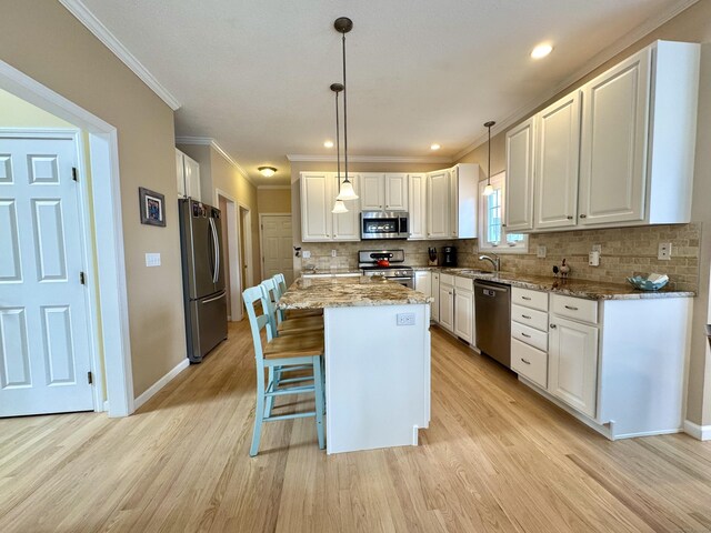 39 Farmstead Ln, Suffield, CT 06078 - kitchen featuring appliances with stainless steel finishes, a sink, light wood-type flooring, white cabinets, and crown molding