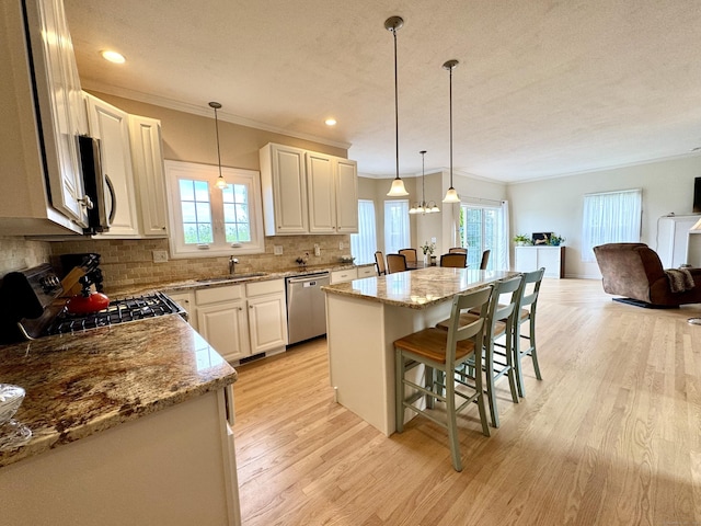 39 Farmstead Ln, Suffield, CT 06078 - kitchen with stainless steel appliances, a sink, a kitchen bar, a center island, and light wood finished floors