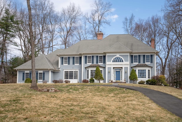 7 Brighton Ln, Simsbury, CT 06070 - colonial inspired home featuring a chimney, a front yard, and driveway