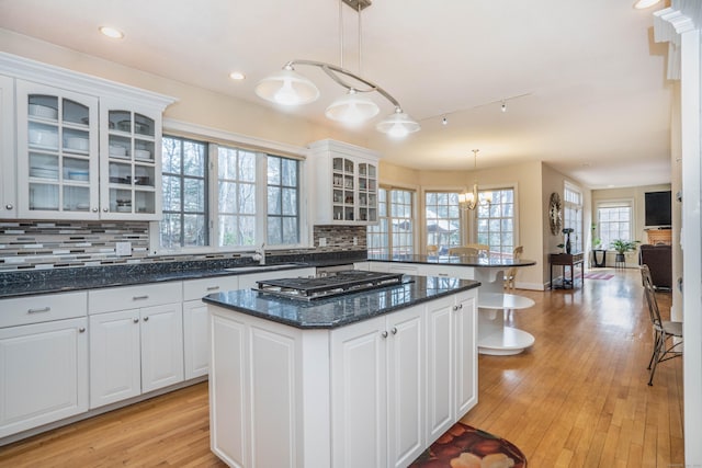 7 Brighton Ln, Simsbury, CT 06070 - kitchen featuring a peninsula, a sink, white cabinets, decorative backsplash, and stainless steel gas cooktop