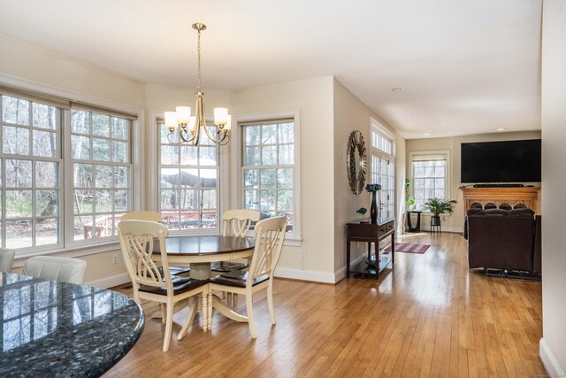7 Brighton Ln, Simsbury, CT 06070 - dining area featuring baseboards, light wood-style flooring, and a notable chandelier