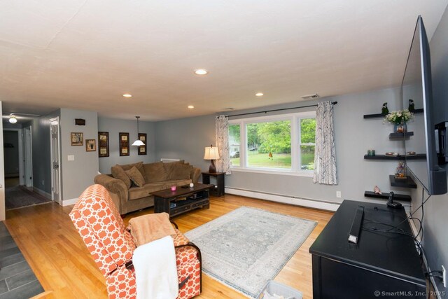 86 Rustic Ln, East Hartford, CT 06118 - living area with baseboard heating, wood finished floors, baseboards, and recessed lighting