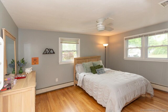 86 Rustic Ln, East Hartford, CT 06118 - bedroom featuring a baseboard heating unit, light wood-type flooring, and a ceiling fan