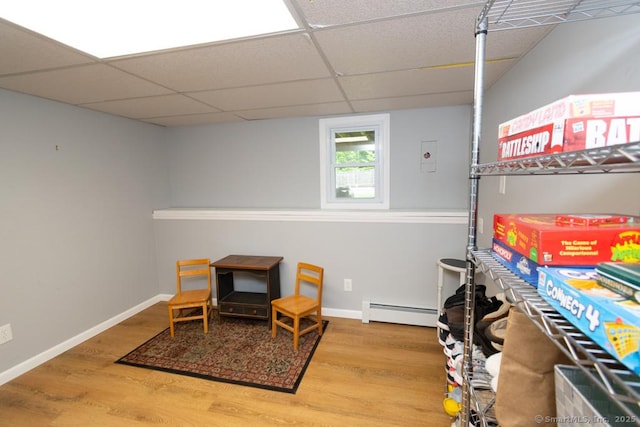 86 Rustic Ln, East Hartford, CT 06118 - living area with baseboard heating, wood finished floors, a drop ceiling, and baseboards