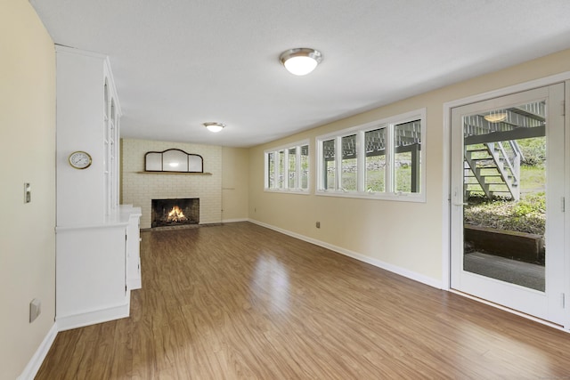 102 Colonial Rd, Guilford, CT 06437 - unfurnished living room featuring wood finished floors and a brick fireplace
