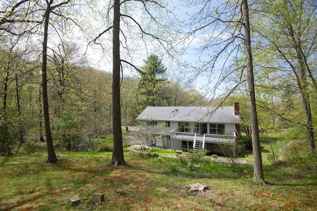 102 Colonial Rd, Guilford, CT 06437 - back of property featuring a chimney, a deck, and a view of trees