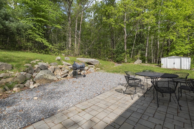 451 Cow Hill Rd, Groton, CT 06355 - view of patio featuring outdoor dining space, a shed, an outdoor structure, a grill, and a view of trees
