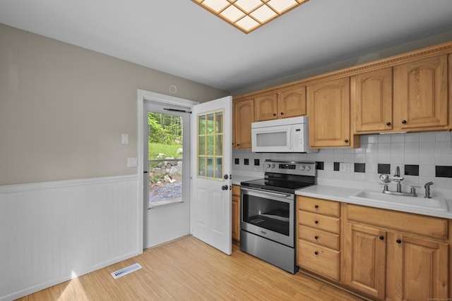451 Cow Hill Rd, Groton, CT 06355 - kitchen featuring white microwave, electric stove, a sink, light wood-style flooring, and a wainscoted wall