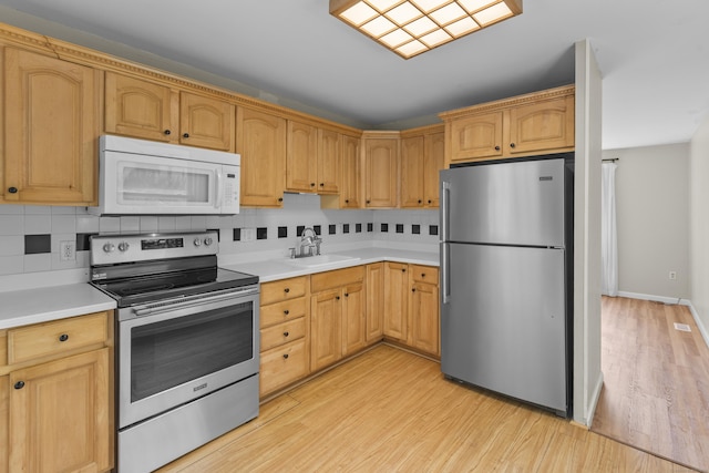 451 Cow Hill Rd, Groton, CT 06355 - kitchen with appliances with stainless steel finishes, light wood finished floors, a sink, light countertops, and tasteful backsplash