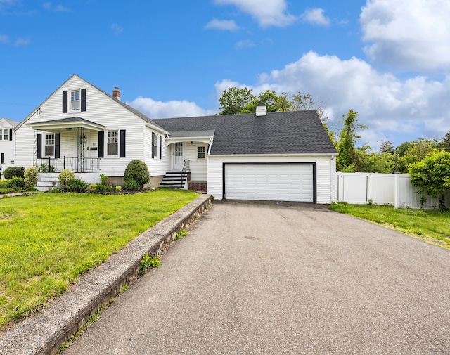 81 Summit St, Southington, CT 06489 - view of front facade with a chimney, asphalt driveway, an attached garage, and covered porch