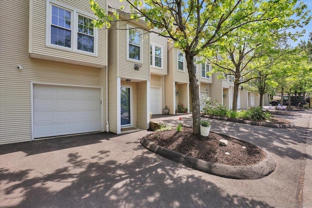 view of property featuring a garage, driveway, and a residential view