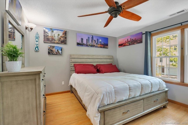 bedroom featuring light wood-type flooring, baseboards, and a ceiling fan