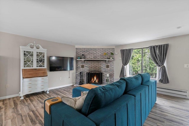 44 Mohawk Trl Unit 44, Guilford, CT 06437 - living area featuring a baseboard heating unit, a brick fireplace, baseboards, and wood finished floors