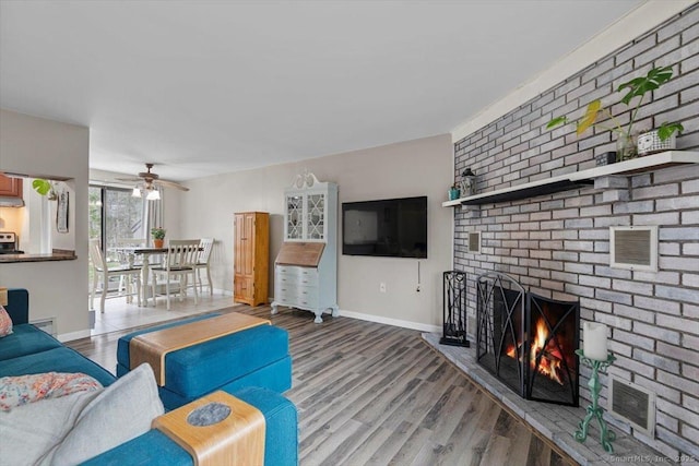 44 Mohawk Trl Unit 44, Guilford, CT 06437 - living area with wood finished floors, a brick fireplace, visible vents, baseboards, and ceiling fan